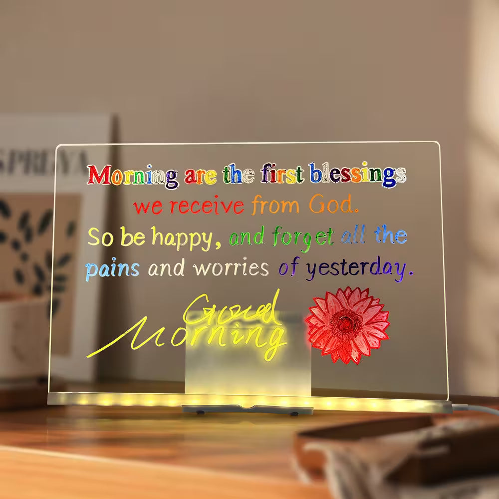 Decorative LED sign with inspirational quote and flower design on a wooden surface.