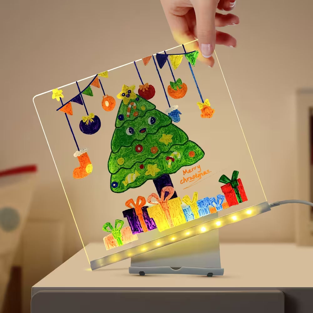 Decorative LED sign with a Christmas tree and presents design, held by a hand.