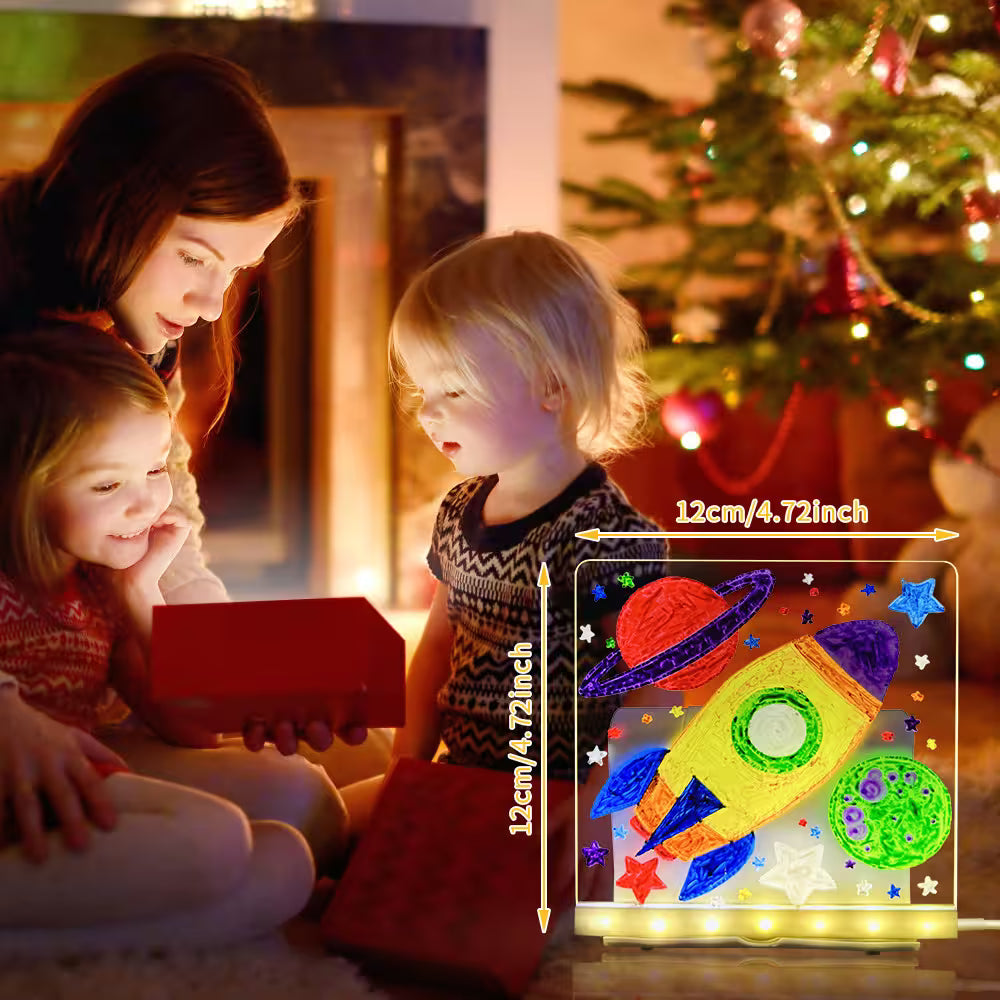 Children looking at a glowing space-themed light box with a Christmas tree in the background.