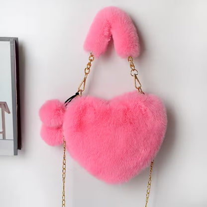 Pink fluffy handbag with gold chain on a white background
