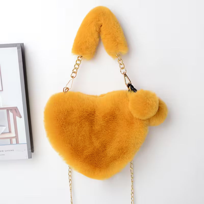 Yellow fluffy heart-shaped bag with chain strap on a white background