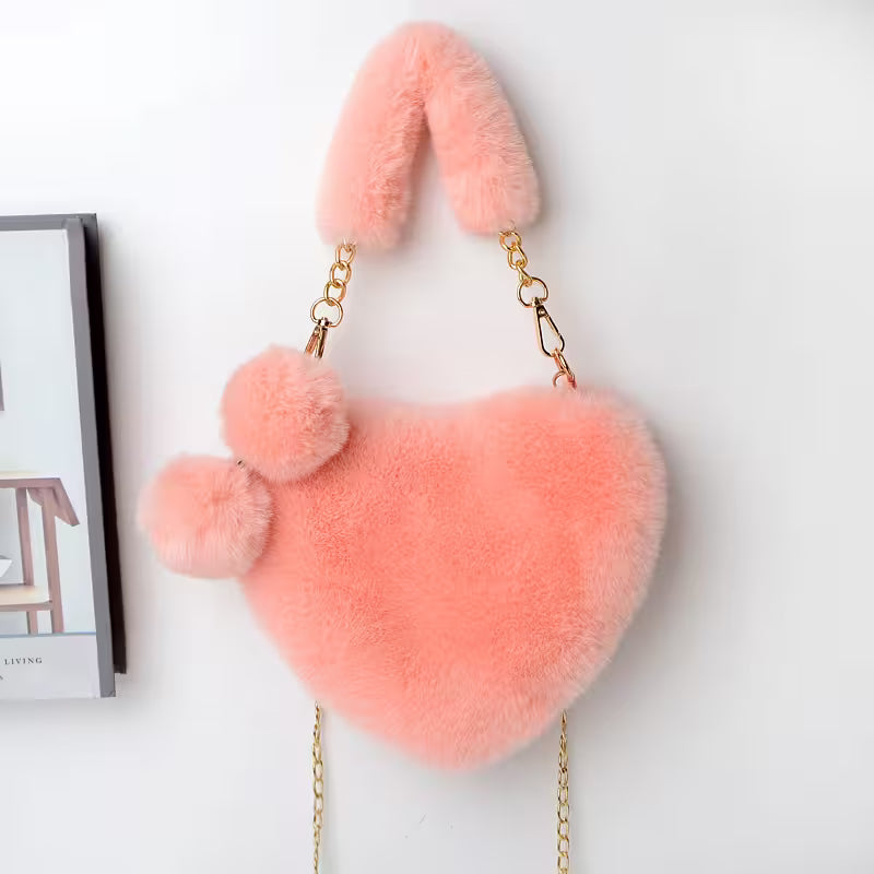 Heart-shaped pink fluffy bag with fur details on a white background