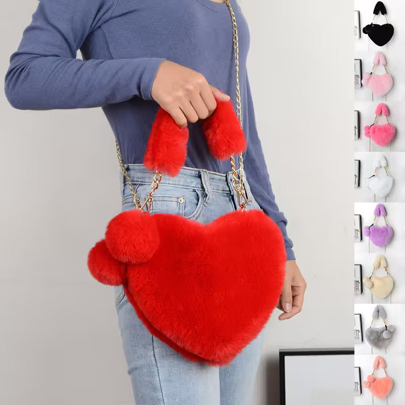 Red heart-shaped fluffy bag held by a person with a gray background