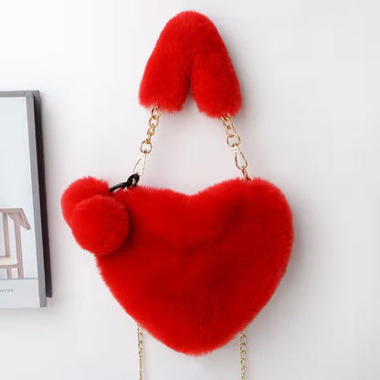Red heart-shaped fluffy handbag with gold chain on a white background