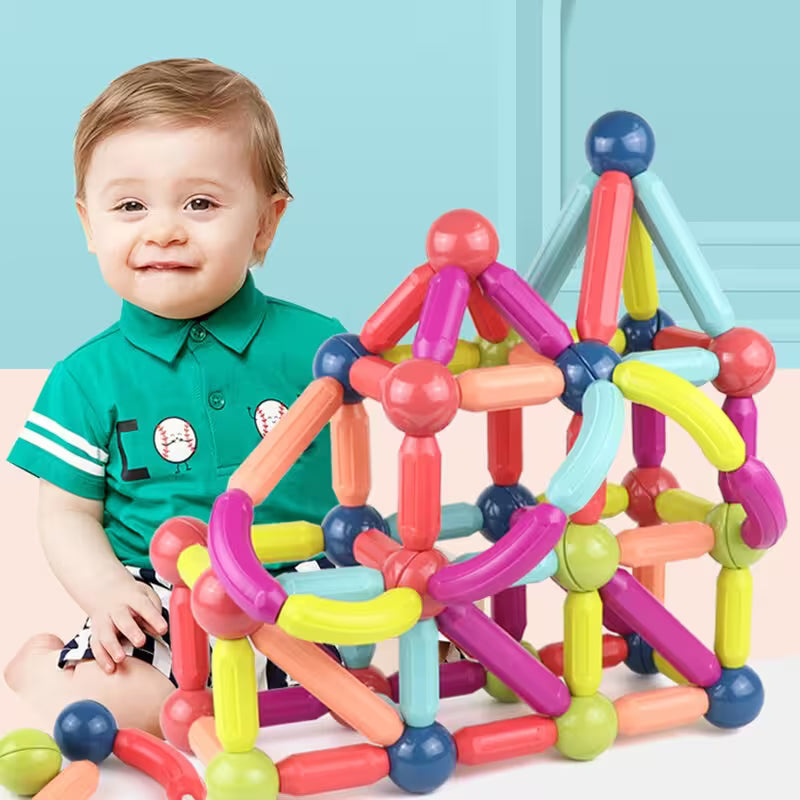 Child playing with colorful magnetic building blocks against a light blue background