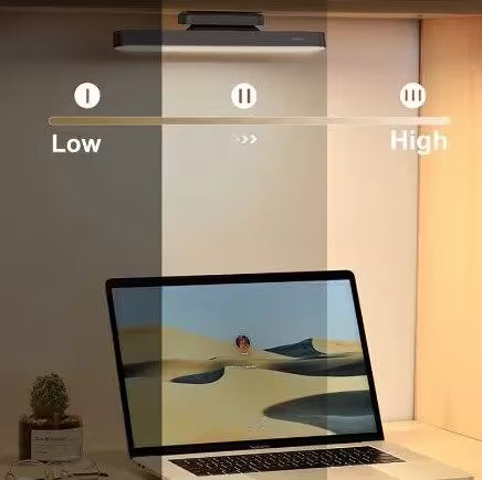 Laptop on a desk with a light bar above it, showing different brightness levels.