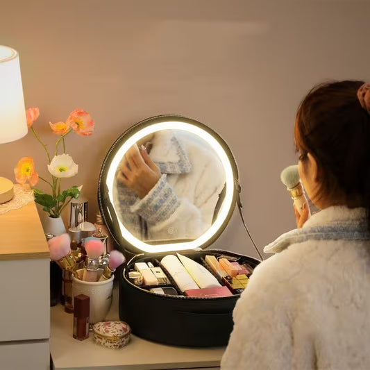 Person applying makeup in front of a round mirror with lights on a vanity table.