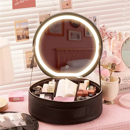 Round makeup case with a lit mirror on a pink surface with beauty products.