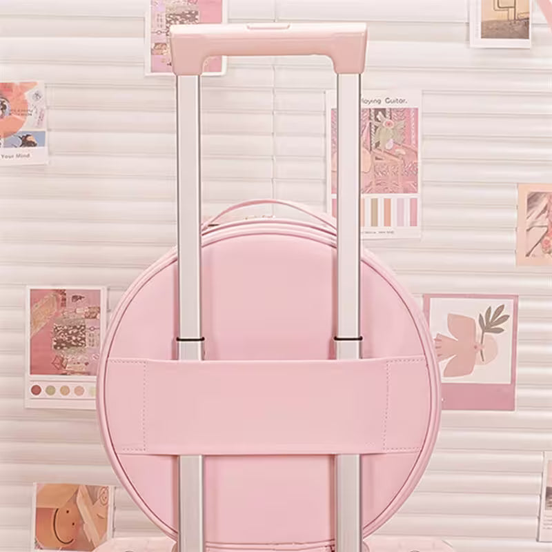 Pink suitcase with a handle against a light-colored wall with decorative elements