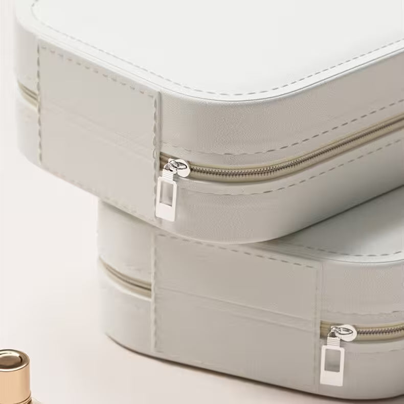 Stack of light gray jewelry boxes with zippers on a white background