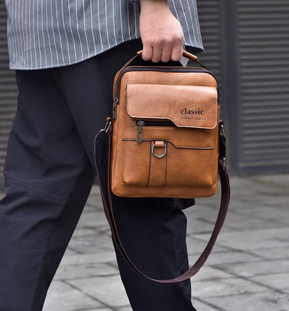 Person holding a brown leather bag with 'classic' branding on a blurred background