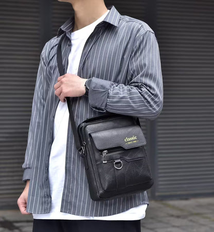 Person wearing a gray striped shirt holding a black leather bag with 'classic' branding.