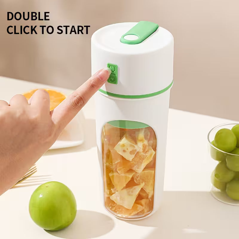 Hand pressing a button on a white and green blender with fruits inside, surrounded by apples and grapes.