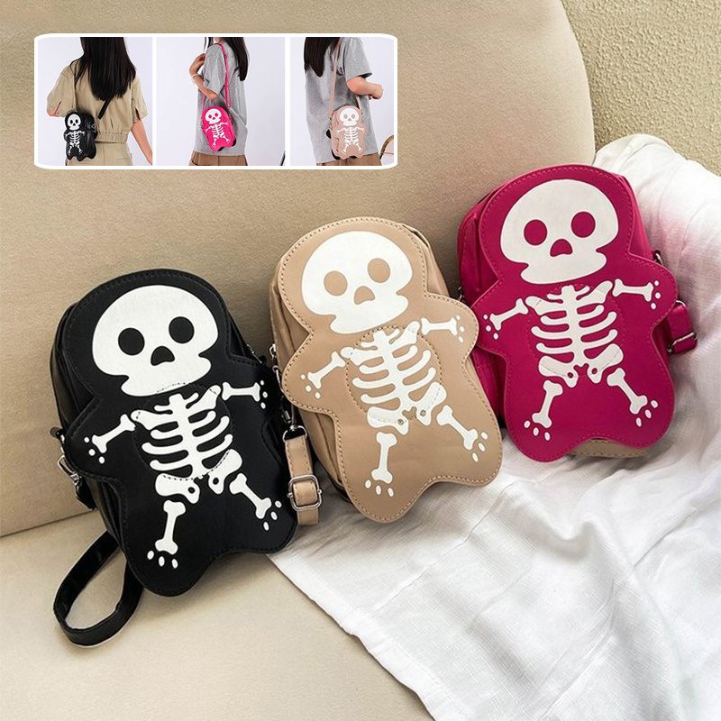 Three skeleton-themed bags in black, beige, and pink on a couch.