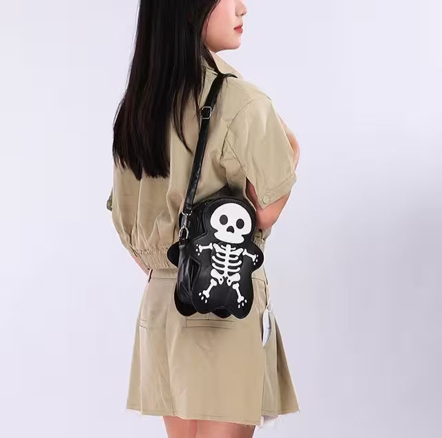 Person wearing a beige jacket with a black skeleton handbag featuring a skull design.