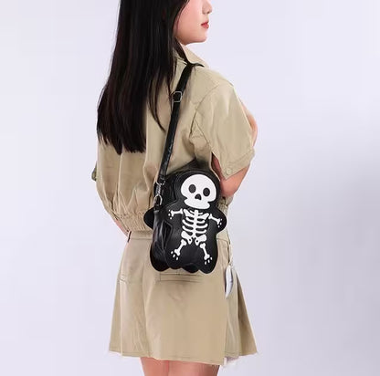 Person wearing a beige jacket with a black skeleton handbag featuring a skull design.