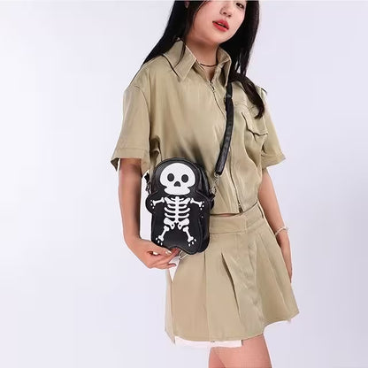 Person wearing a beige shirt and skirt with a black skeleton-patterned bag on a white background
