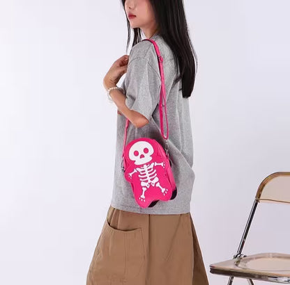 Person wearing a gray shirt and brown pants with a pink skeleton bag on a white background