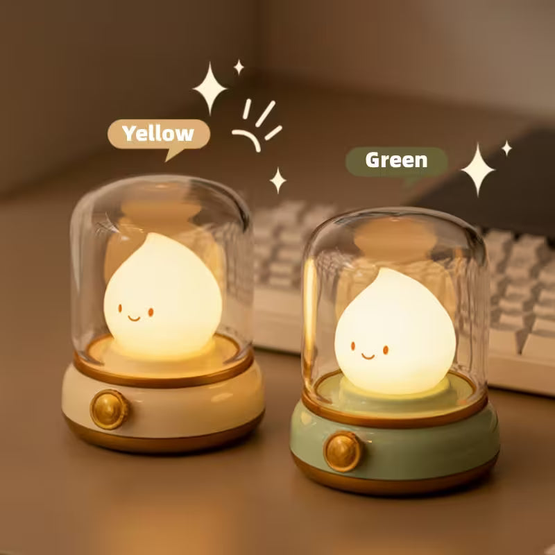 Two cute night lights, one yellow and one green, on a surface with a blurred background.