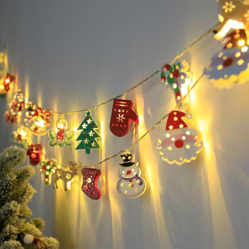 Decorative string lights with Christmas-themed ornaments on a wall.