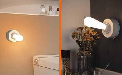Modern wall-mounted light fixtures in a bathroom setting with a vase of flowers.