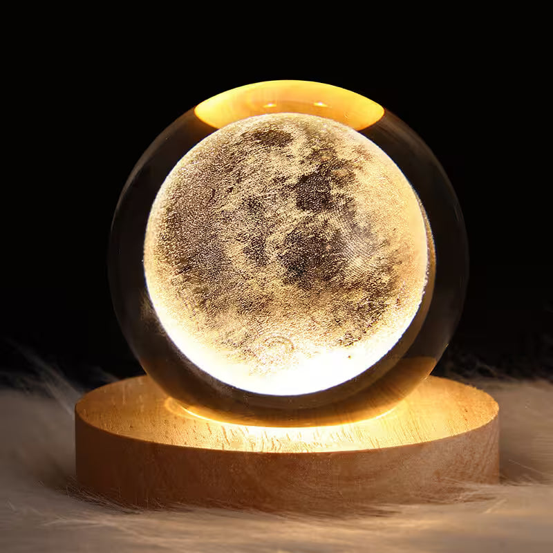 Moon lamp with detailed surface on a wooden base against a dark background