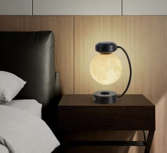 Table lamp on a nightstand next to a bed with wooden headboard