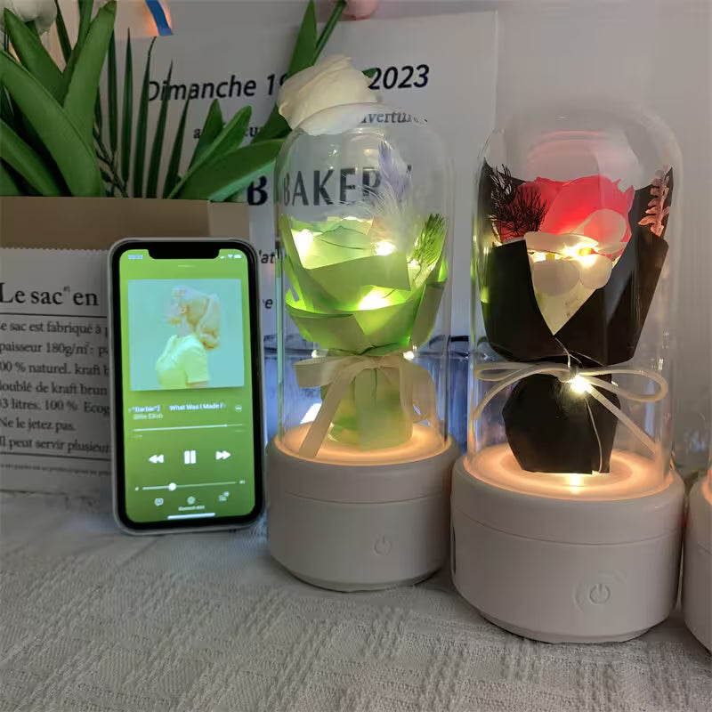 Two illuminated glass containers with lights on a surface next to a smartphone displaying music app.