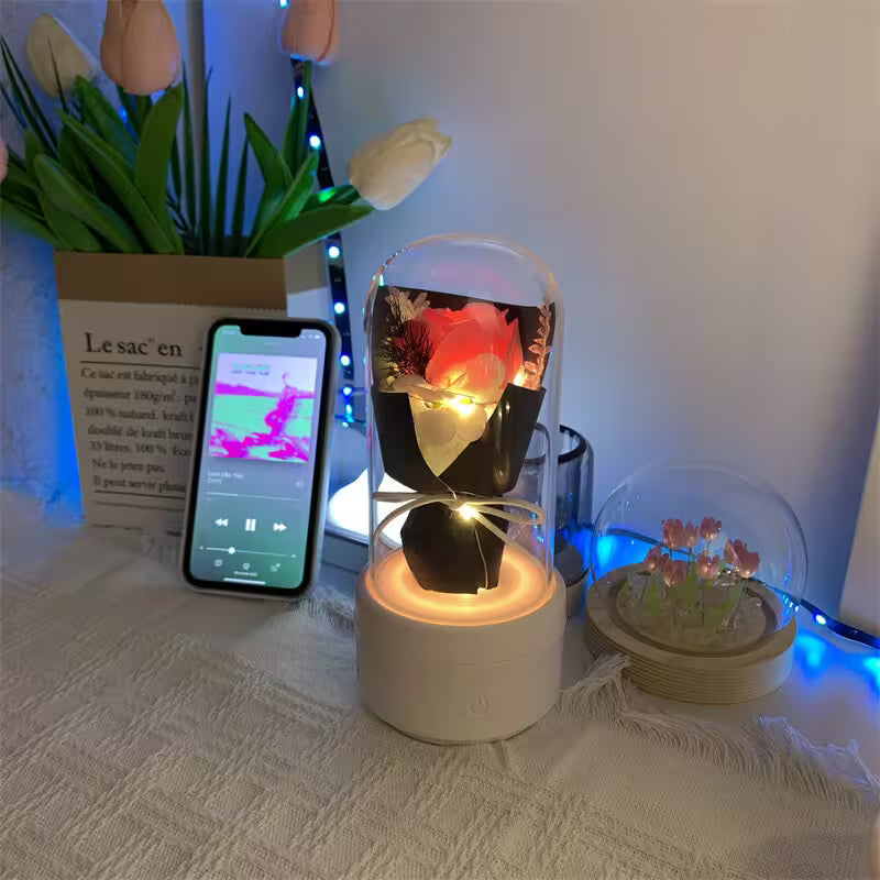 Decorative setup with a lit candle, smartphone, and small plant on a textured surface.