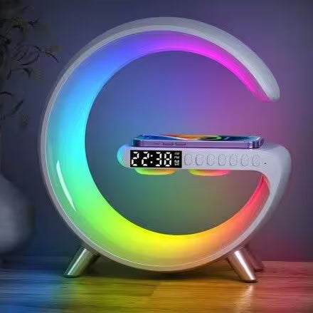 Colorful crescent-shaped night light with digital display on a wooden surface.