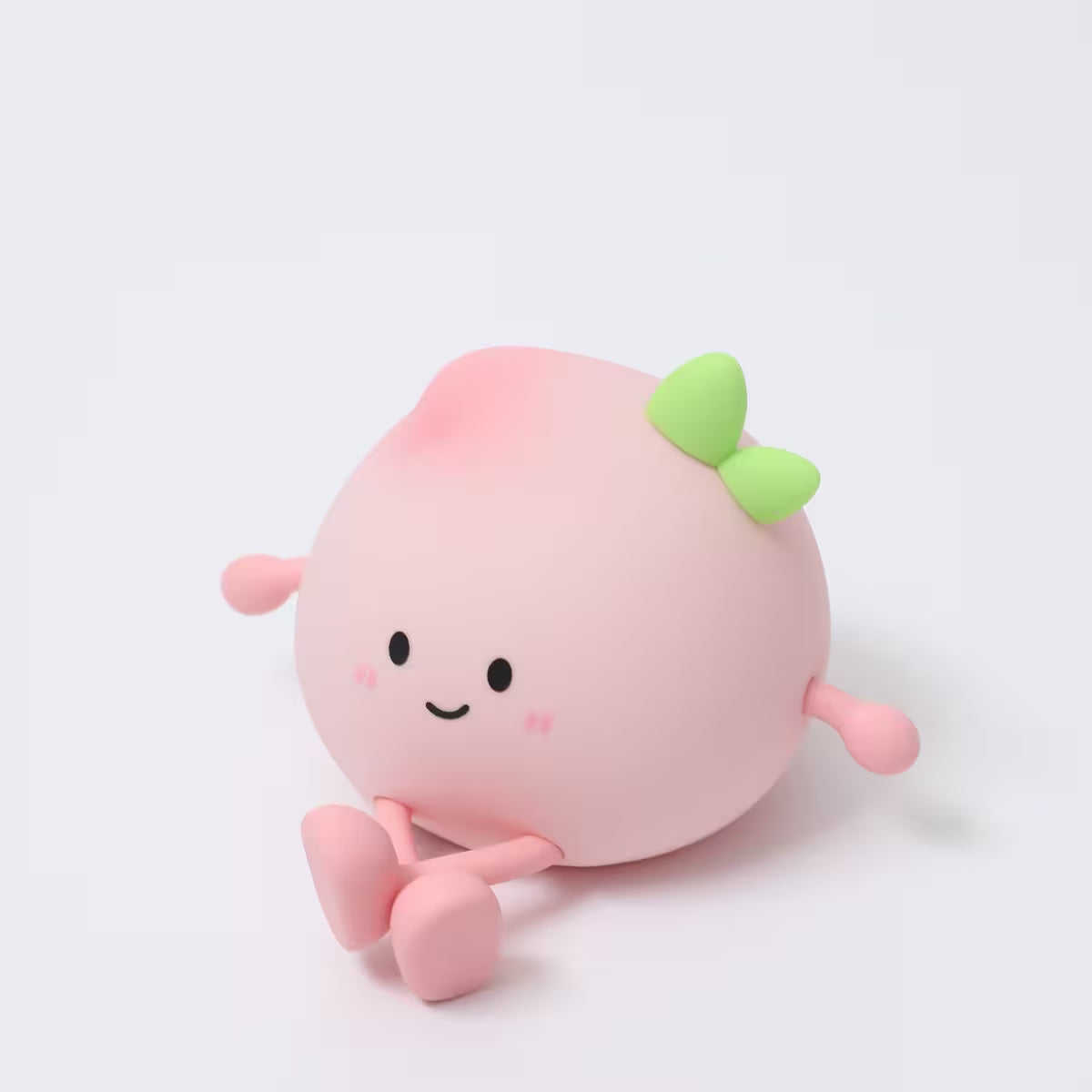 Pink plush toy with a green leaf on a white background
