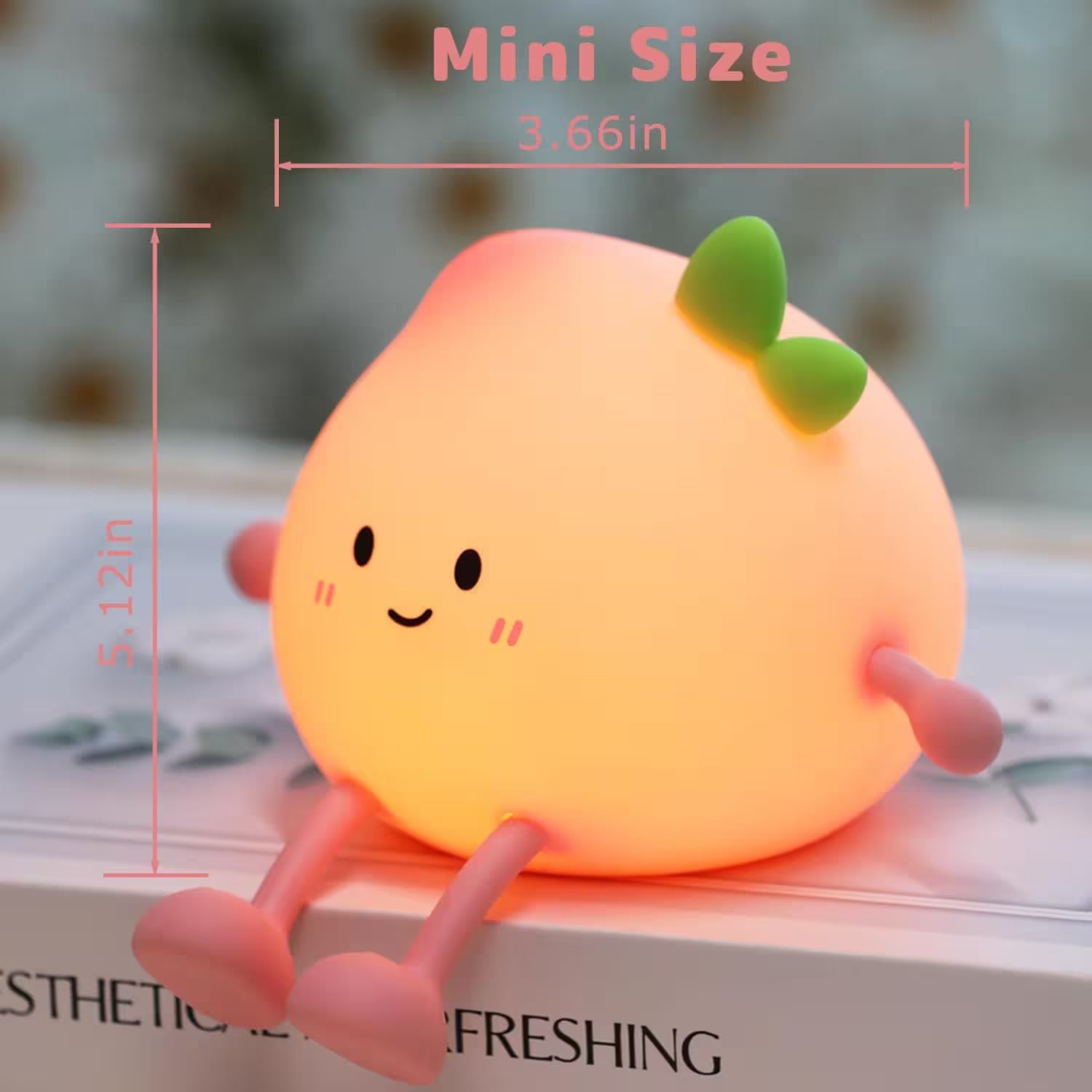 Small, round, orange-colored lamp with a green bow and measurements on a blurred background