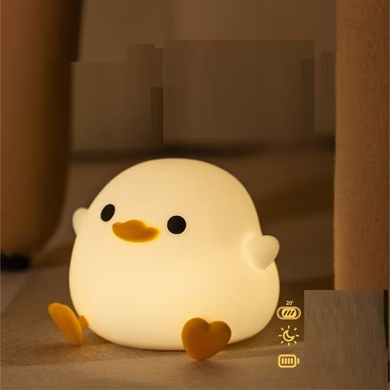 Cute chick-shaped night light on a wooden surface with a warm glow.