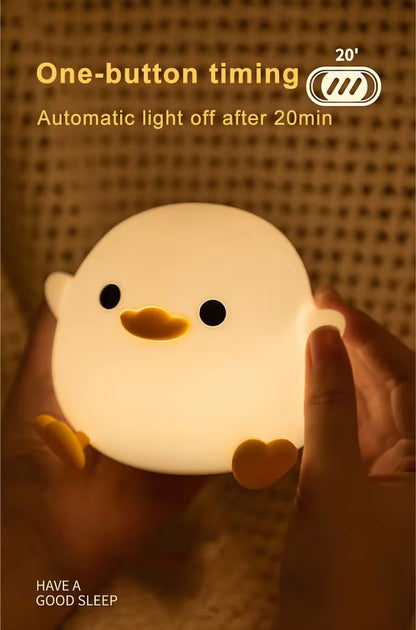 Light-up duck-shaped night light held by a hand with text about one-button timing and automatic off feature.