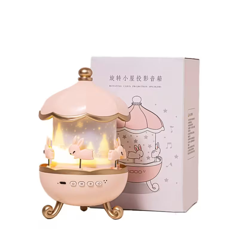 Pink carousel-shaped projection speaker with packaging on a white background
