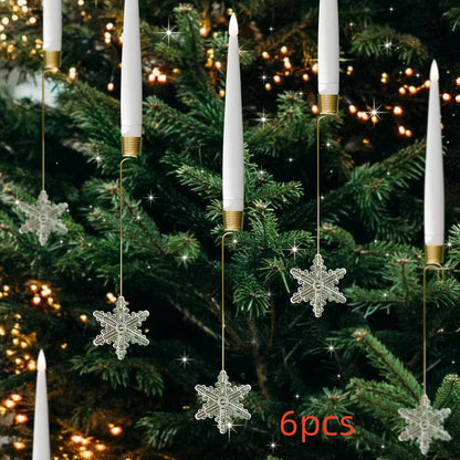 Decorative candles with snowflake ornaments hanging on a Christmas tree.