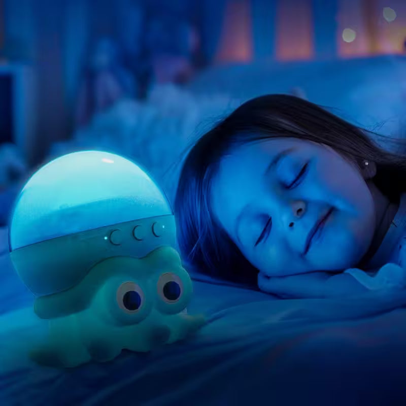 Child sleeping with a glowing octopus-shaped night light in a dimly lit room.