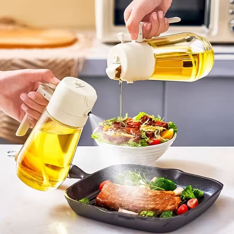 Two bottles of oil being used on a salad and pan with food in a kitchen setting.
