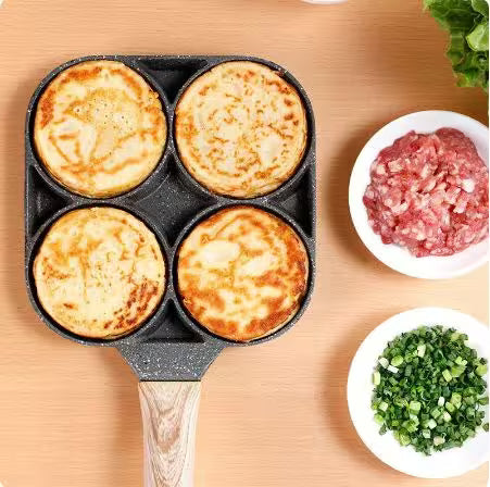 Four cooked pancakes in a pan with bowls of ground meat and chopped vegetables on a wooden surface.