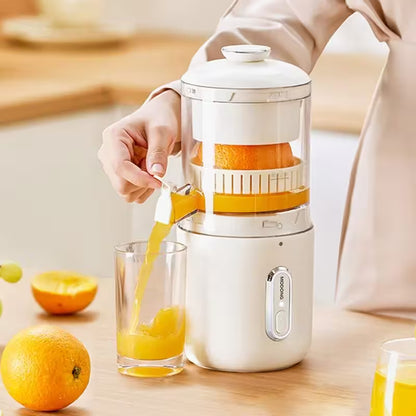 Person using a manual juicer to extract juice from oranges, with a glass of orange juice on a wooden table.