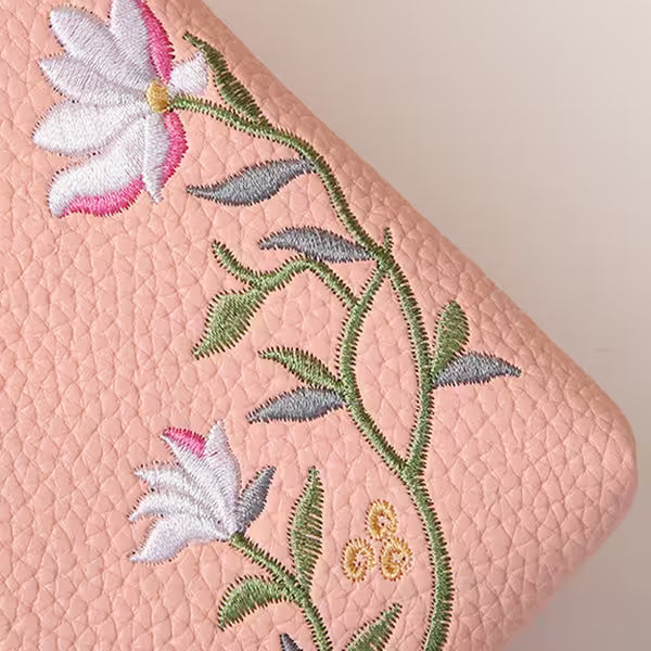 Embroidered floral design on a pink textured surface