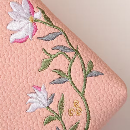 Embroidered floral design on a pink textured surface