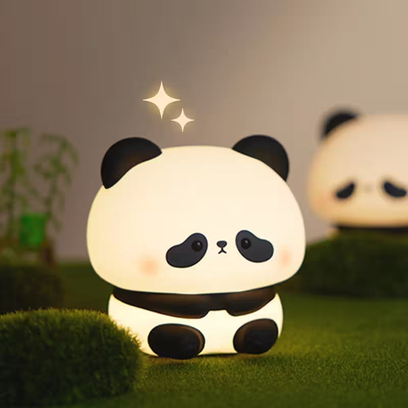 Cute panda-shaped night light on a grassy surface with a blurred background