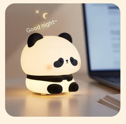 Cute panda-shaped night light with 'Good night' text on a desk next to a laptop.