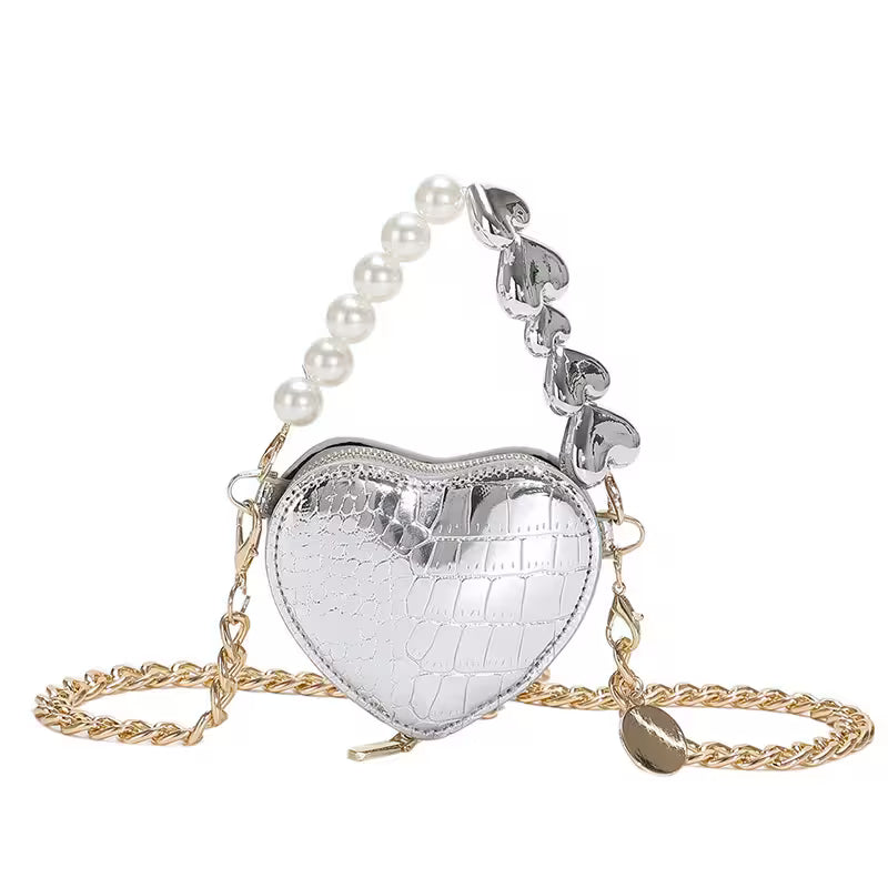 Heart-shaped silver bag with pearl chain on a white background