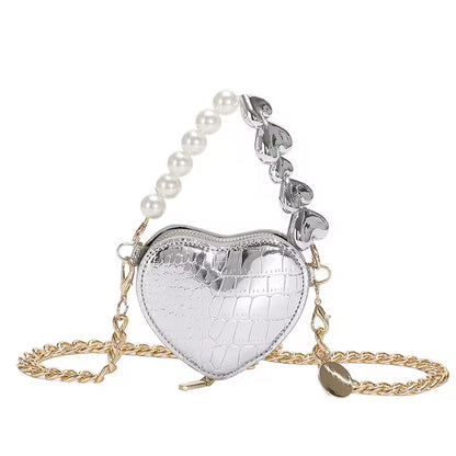 Heart-shaped silver bag with pearl chain on a white background