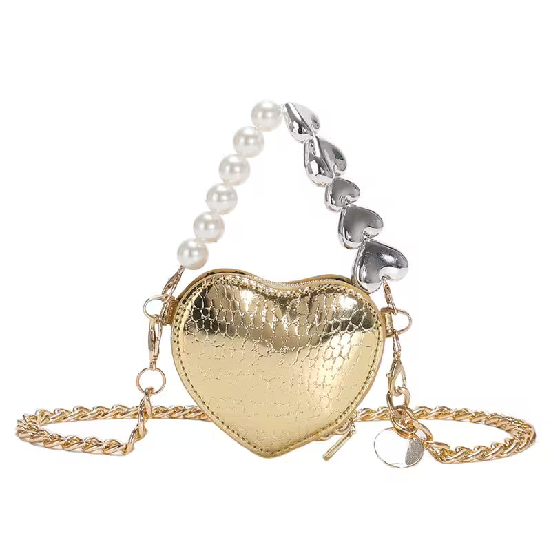 Heart-shaped gold bag with a pearl and silver chain on a white background