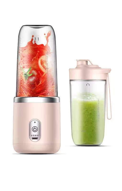 Portable blender with a pink base and clear container filled with green juice on a white background