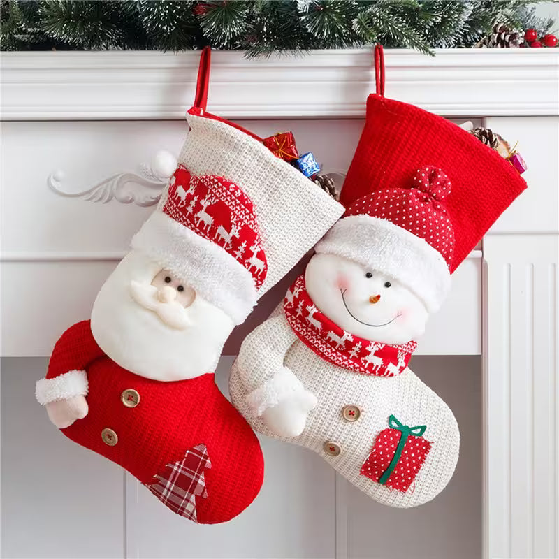Two Christmas stockings with Santa and snowman designs hanging against a white wall.