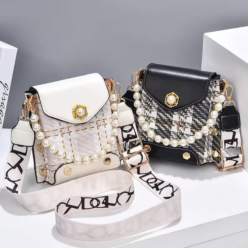 Two handbags, one white and one black, with decorative straps and embellishments on a gray background.